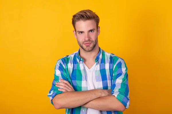 Sérieux beau jeune homme portrait garder les bras croisés en chemise à carreaux, confiant — Photo