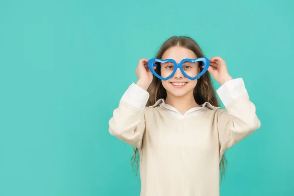 Vrolijk kind in partij bril op blauwe achtergrond met kopieerruimte, jeugd — Stockfoto