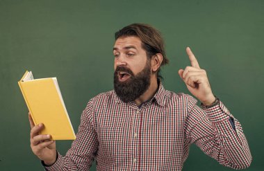 gayri resmi eğitim. Erkek öğrenci ders sırasında sınıfta oturur. Sınavı geç. Konuyu öğrenmek. Okula dönüyorum. Öğretmenler günün kutlu olsun. Sakallı acımasız adam kitap tutuyor. edebiyat ve okuma