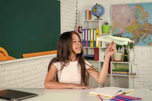 Vamos a volar. desarrollo infantil. obtener conocimiento a través del estudio. niño en el aula con pizarra. niño mantenga plano de papel. de vuelta a la escuela. educación formal en la vida moderna. concepto de educación en el hogar — Foto de Stock