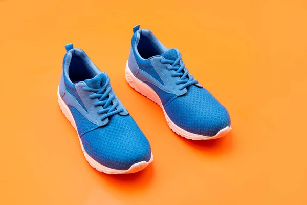 Sneakers sportive blu coppia su sfondo arancione, sport — Foto Stock