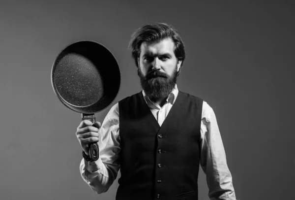 Elegante hombre sostiene sartén utensilio de cocina, concepto de comida asada —  Fotos de Stock