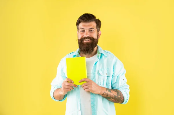 Glücklicher bärtiger Mann mit Buch auf gelbem Hintergrund, Bildung — Stockfoto