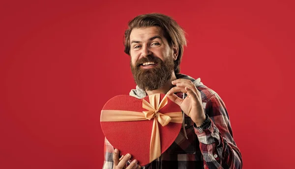 Szakállas férfi hipster kockás ingben tartsa szív doboz ajándék, szerelem — Stock Fotó
