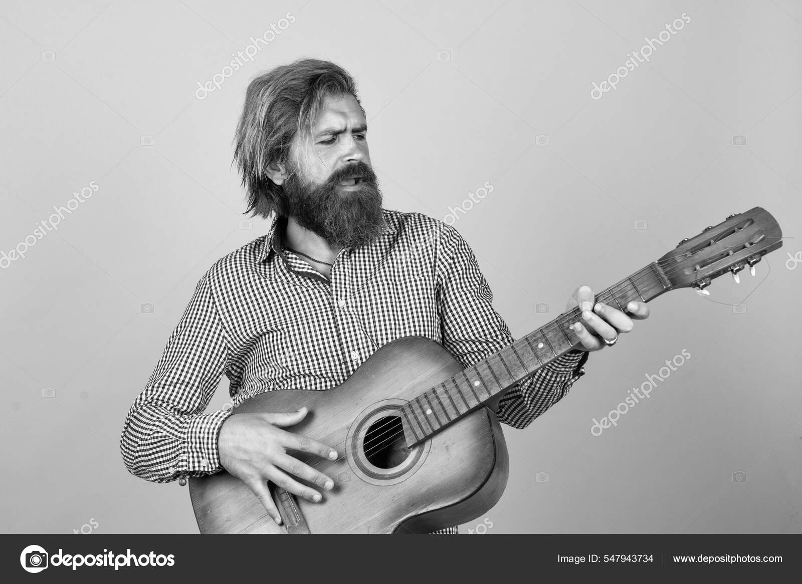 Brutal mann. Han med skjegg og bart spiller gitar. Skjeggete mann i rutete  trøyesang. Musikalsk artist. musikalsk strengeinstrument. moden karismatisk  mannlig gitarist – stockfoto © stetsik #547943734, image size:1600x1166