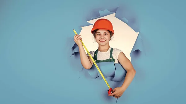 Controllo ogni dettaglio alla ricerca di difetti. bambino indossare il casco in cantiere. teen girl builder con strumento di costruzione metro a nastro. bambino sul lavoro di riparazione. concetto di ristrutturazione in officina — Foto Stock