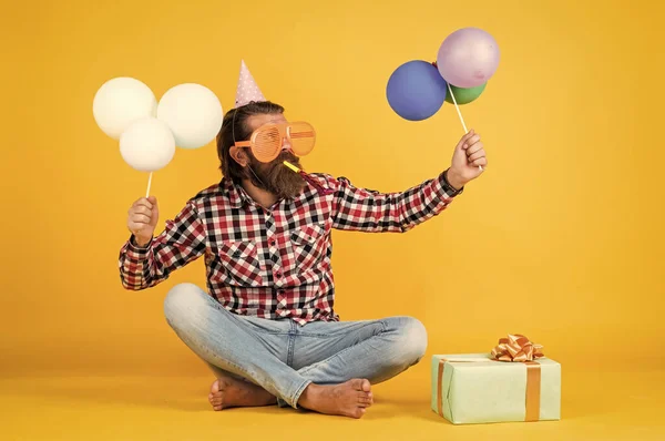 Alles Gute zum Geburtstag. bärtige reife Männer feiern Geburtstagsparty. Ein fröhlicher Mann mit Bollenhut hält Urlaubsballons in der Hand. Geschenke und Geschenke Konzept. Wir wünschen Ihnen einen schönen Urlaub. Partyzeit — Stockfoto