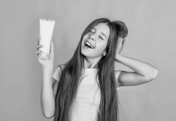 Chica alegre condición de pelo con plancha. niño adolescente limpiando cabello con champú. niño presentando gel de ducha. cosmética para el cuidado corporal. loción o exfoliación cutánea. fuerte y resistente. Solía verse perfecto. — Foto de Stock