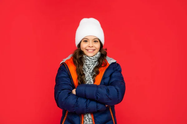 Tonåring flicka på röd bakgrund. porträtt av barn som bär varma kläder med halsduk. — Stockfoto
