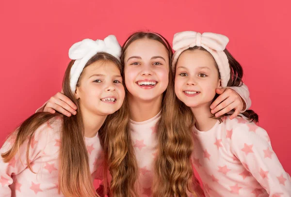 Портрет счастливых детей с улыбающимися лицами в домашней одежде розовый фон — стоковое фото