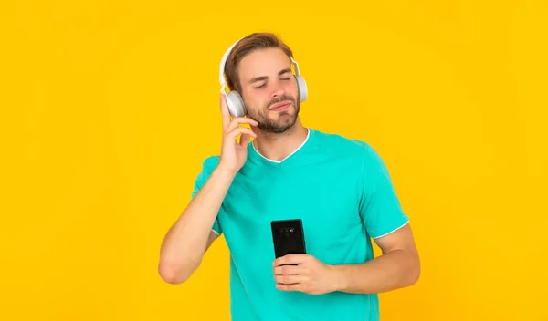 Užij si svůj den s pozitivitou. Šťastný chlapík si užívá hudbu ve sluchátkách. Ztracen ve svém vlastním světě — Stock fotografie