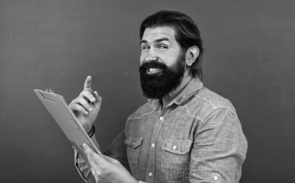 Homem bonito com barba e bigode mostrando papel de documento para fazer notas, verificando resultados — Fotografia de Stock