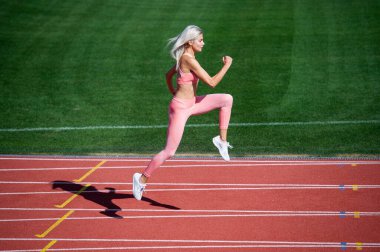 Formda bayan spor ve hız yaparken stadyum yarış pistinde koşuyor.