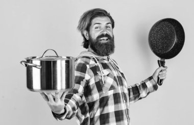 Tutkuyla yemek pişirmek. Profesyonel aşçı. Sakallı adam mutfak tepsisini tut. Tencereli vahşi hippi yemekleri. Hizmetçi koca, tencerede yemek yapıyor. Kareli gömlekli olgun bir aşçı. Evde yemek hazırla.