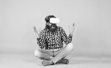 Yeni gerçeklik burada. Mutlu gelecek. Adam kablosuz internet gözlüğü takıyor. VR kulaklıklı adam. Sakallı hippi modern teknoloji kullanır. Dijital gelecek ve yenilik. Sanal gerçeklik gözlüğü takan acımasız bir adam.