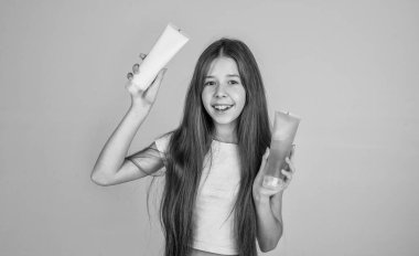 Sevimli kız çocuğunun moda bir saç stili var ve şişede ya da fırçada losyon kullan, güzellik blogu.