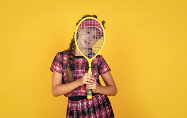 トレーニング後のリラックス。スポーツ用品を持ってる幸せな女の子。子供はテニスラケットを持っている。子供はフィットネスキャップを着用する。子供の頃の活動。健康的な生き方だ。元気を出しなさい。ラケット付きバドミントン選手 — ストック写真