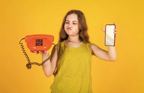 Ребенок держать ретро и современный телефон для разговоров, выбор — стоковое фото