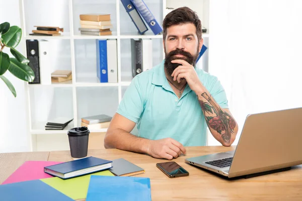 Glücklicher Mann streicht am Schreibtisch über das Kinn, professionell — Stockfoto