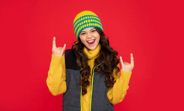 Capretto emotivo fresco con capelli ricci in cappello. teen ragazza su sfondo rosso. — Foto Stock