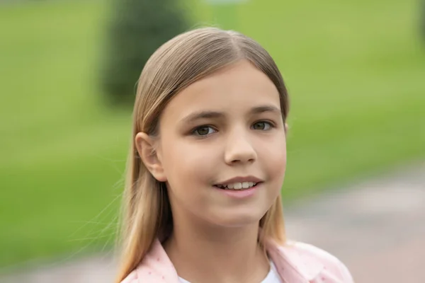 Portret van een gelukkig meisje kind met een glimlachend gezicht buiten — Stockfoto