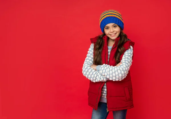Zimowa moda. skopiować przestrzeń. szczęśliwe dziecko z kręconymi włosami w kapeluszu skrzyżowane ręce. modelka modelek — Zdjęcie stockowe