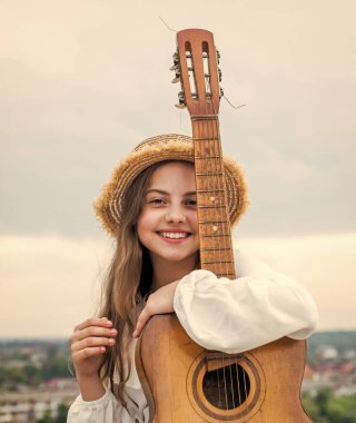 Şık bir kız çocuğu gitar çalıyor, country müzik çalıyor.