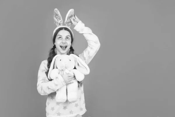 Kindergeluk. kind in konijnenoren en pyjama. Tijd voor plezier. schattig kind spelen met speelgoed — Stockfoto