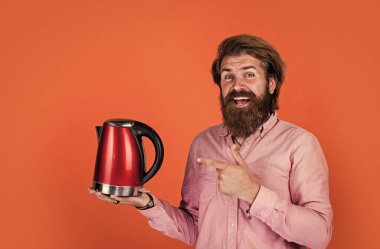 Olgun sakallı adam sıradan görünüyor. Çaydanlık, çay.