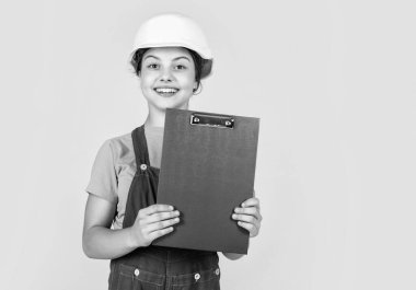 Çocuk inşaat alanında kask takıyor. İnşaat işleri yapan genç bir inşaatçı kız. Çocuk tamir işiyle uğraşıyor. Atölyede yenileme konsepti. Meşgul profesyonel marangoz. İnşaat mühendisi mimar