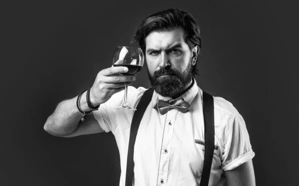 Be a thinker not a drinker. sommelier tasting alcohol. bearded man in suspenders drink red wine. brutal guy bartender in bow tie. elegant male barman. handsome hipster drinking wine glass