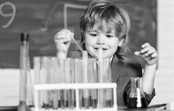 Jongen gebruikt microscoop reageerbuizen chemie school klaslokaal. Hij studeert scheikunde. Biotechnologie en farmacie. Geniale leerling. Chemische analyse. Wetenschapsconcept. Wunderkind experimenteert met chemie — Stockfoto