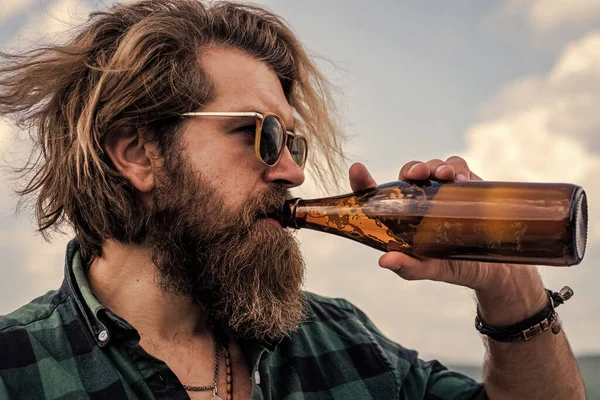 Hydration concept. bearded man in checkered shirt drink water from bottle. casual guy drinking beer. brutal hipster with long hair and moustache relax outdoor. male health care — Stock Photo, Image