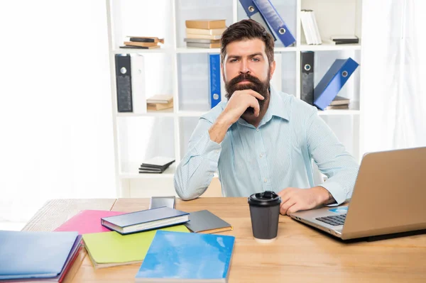 Gestionnaire sérieux pensant assis au bureau sur le lieu de travail — Photo