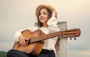Moda görünümlü kız akustik gitar çalıyor, şarkıcı.