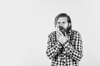 dişçi muayenesi. Sıradan kıyafetler içindeki yakışıklı sakallı adam. Acı çeken beyaz bir adam. Vahşi sakallı hippinin dişleri ağrıyor. Erkek dişlerinde ağrı hisseder. Sıradan bir erkeğin tıbbi bakıma ihtiyacı var.