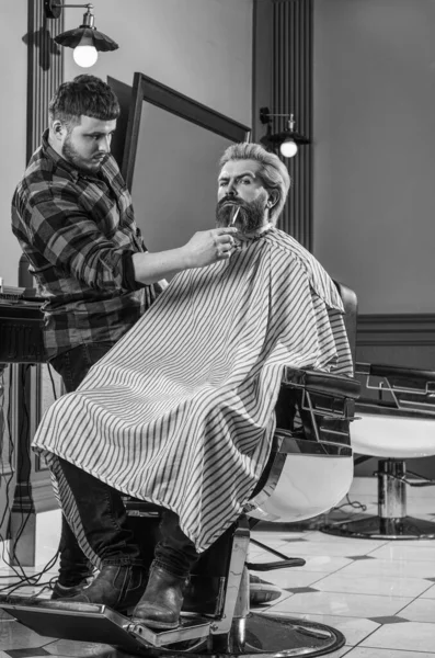 Barbudo e elegante. barbear. Cabeleireiro na barbearia. homem no salão de cabeleireiro com corte de cabelo hipster. barba e bigode. Cabeleireiro profissional no interior da barbearia. Retrato de barba de homem elegante — Fotografia de Stock