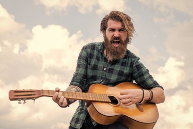 Yakışıklı sakallı, şık saçlı, akustik gitar çalan, müzik çalan adam.