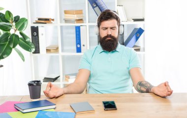 Sakin iş adamı meditasyon yapıyor Mudra 'yı ofiste rahatlatıcı müzik dinleyip meditasyon yapıyor.