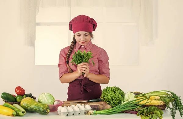 Vrolijk kind meisje koken vitamine salade van groenten, keuken — Stockfoto
