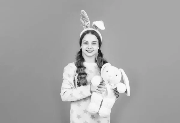 Счастливая пасхальная девочка-подросток в кроличьи уши кролика и пижамы играть с игрушкой, Пасха — стоковое фото