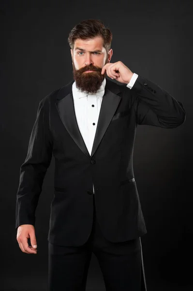 Elegant butler i smoking på svart bakgrund, herrkläder — Stockfoto