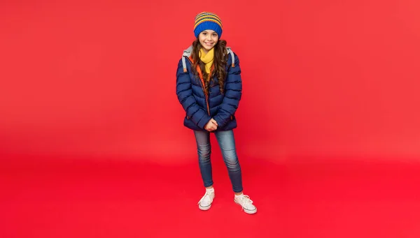Happy kid with curly hair standing in hat. female fashion model. teen girl in down coat. — Stock Photo, Image