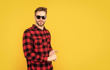 Tıraşsız suratlı kıllı sakallı adam. moda ve güzellik. Berber dükkanı konsepti. Erkekler giyer. Kareli gömlek ve gözlüklü genç yakışıklı adam. şık erkek günlük kıyafetler giyer.