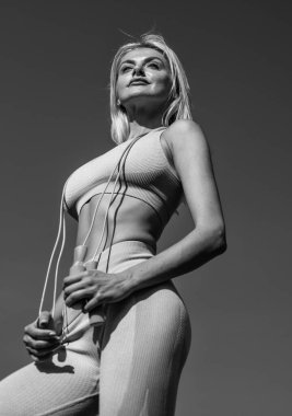 Sıkı çalış, sıkı oyna. Koç ip atlama kullanıyor. Spor başarısı. Atlamak için bir araç. Fitness sporu modası. Bayan atlama egzersizi. Spor giyim sektöründe sportif bayan. Stadyum spor salonundaki seksi kadın. kadın antrenör antrenörü