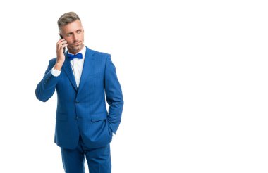 Mavi papyon takım elbiseli adam telefonda konuşur.