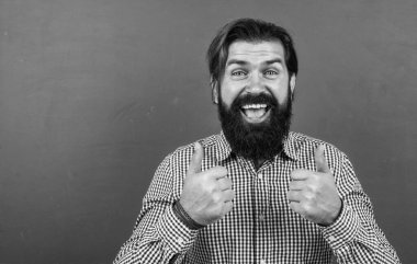 Mutlu sakallı yetişkin hippi baş parmağını gösteriyor, başarı.