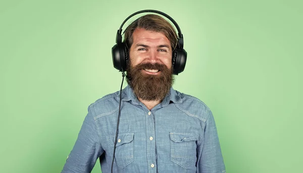 Bebaarde brutale man met snor dragen hoofdtelefoon luisteren muziek, technologie — Stockfoto