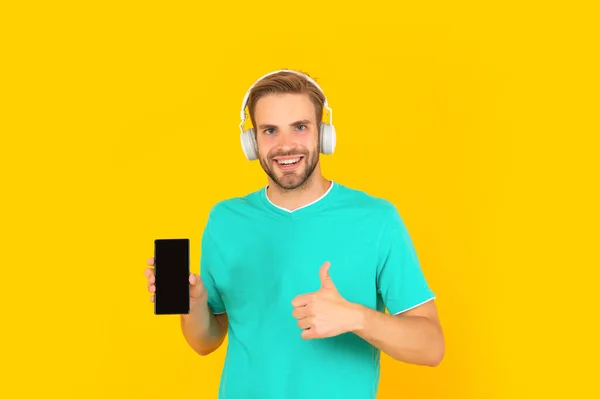 De beste telefoon. De gelukkige man geeft duimen aan zijn mobieltje. Gebruik het om je anders te laten voelen. — Stockfoto