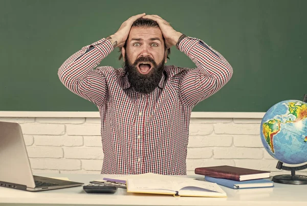 Estudiante masculino se sienta en el aula de la escuela mientras dura lección. aprobar el examen. aprender es difícil. profesor hipster estresado. un hombre sobrecargado de trabajo con barba que tiene estrés. problemas para estudiar. educación formal —  Fotos de Stock